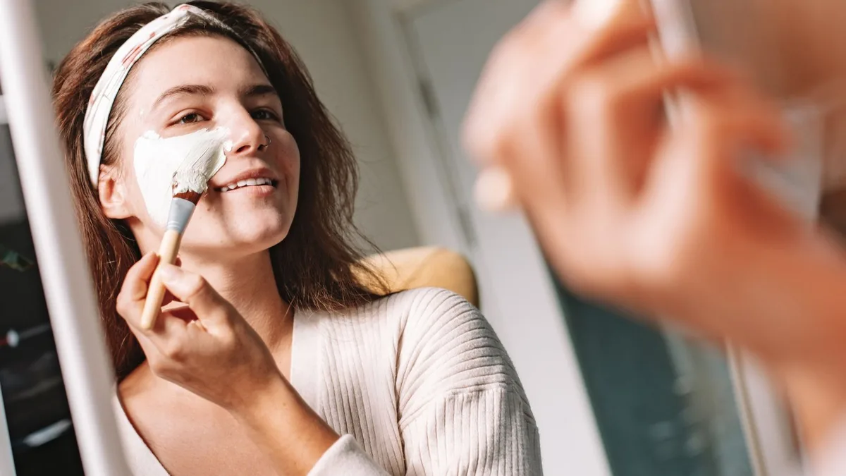 Une femme détendue dans un institut lumineux, soin du visage naturel et ambiance douce et végétale.